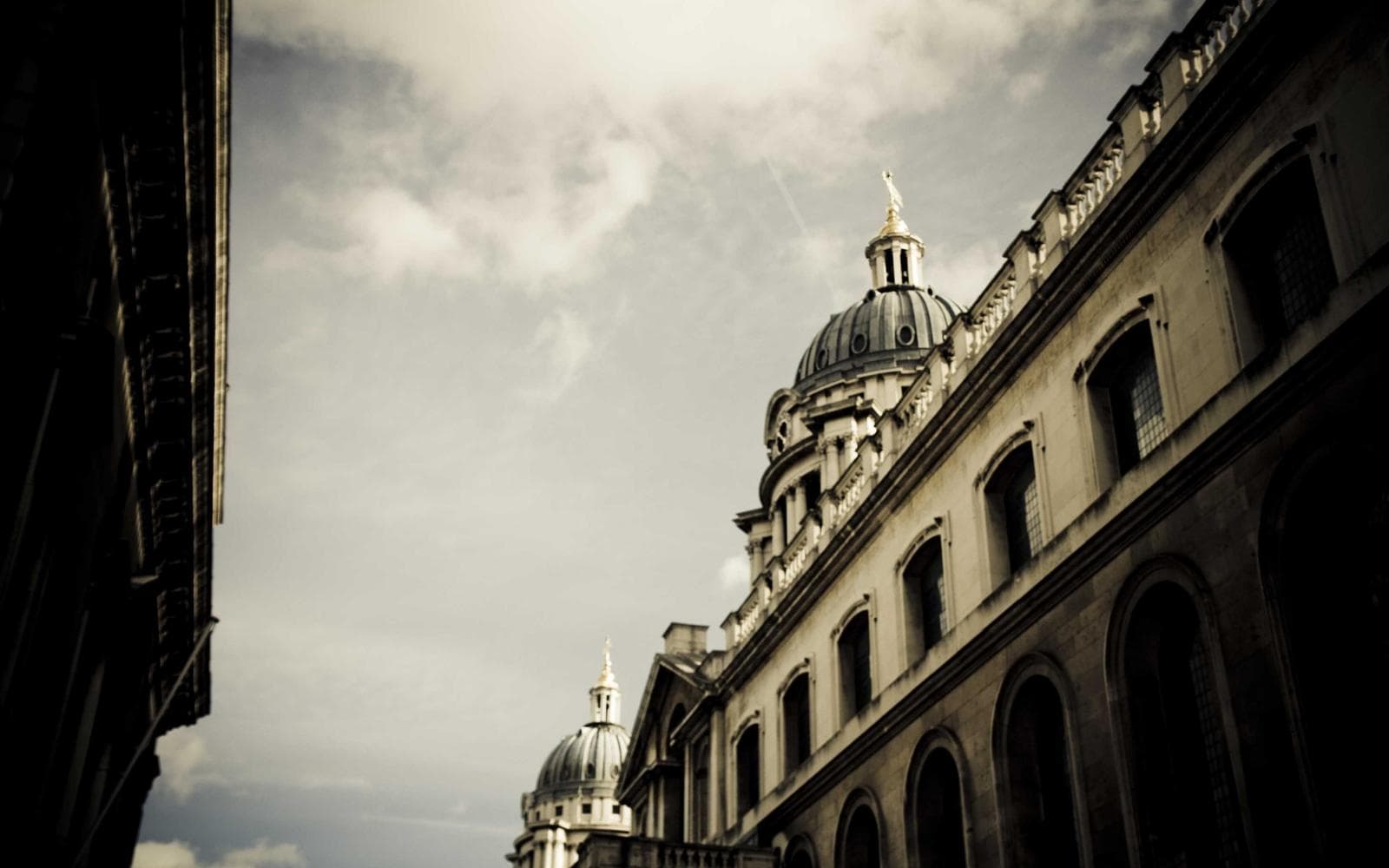 Stone college facade under a cloudy sky, standing in for youth programs